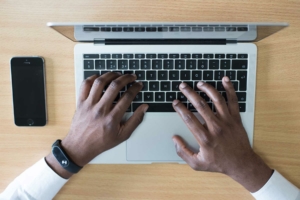 Man typing on a mac laptop